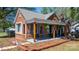 Beautiful brick home showcasing a cozy covered porch with wood columns and neat yard at 2701 N Main Ave, Newton, NC 28658