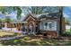 Quaint brick home featuring a covered front porch with rocking chairs and tidy landscaping at 2701 N Main Ave, Newton, NC 28658