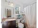 Bright bathroom features a granite vanity, ample storage, and a shower-tub combo with a white curtain at 3005 Kansas City Dr, Monroe, NC 28110