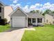 Charming single-story home with manicured lawn, attached garage, and covered front porch at 3005 Kansas City Dr, Monroe, NC 28110