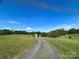 Gravel driveway leading to a barn in a scenic, green pasture setting at 3032 Mckinney Rd, Shelby, NC 28152