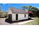 Detached white brick garage with a black door and gravel driveway at 3032 Mckinney Rd, Shelby, NC 28152