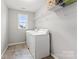 Functional laundry room with modern washer, dryer, and shelving at 3041 Winged Teal Ct, Belmont, NC 28012