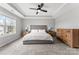 Main bedroom with tufted headboard, tray ceiling, and bright natural light from the window at 3041 Winged Teal Ct, Belmont, NC 28012