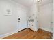 Inviting entryway with hardwood floors, white walls, and a stylish storage cabinet at 3510 Conway Ave, Charlotte, NC 28209