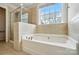 Bright bathroom featuring a soaking tub and a glass shower at 3619 Grove Creek Pond Sw Dr, Concord, NC 28027