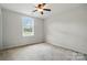 Cozy bedroom with neutral walls, carpeted floors, and a window providing natural light at 3619 Grove Creek Pond Sw Dr, Concord, NC 28027