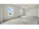 Spacious bedroom with neutral carpet, two windows that bring in natural light, and modern ceiling fan at 3619 Grove Creek Pond Sw Dr, Concord, NC 28027