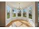 Bright breakfast nook features hardwood floors, a chandelier, and a bay window with views of the backyard at 3619 Grove Creek Pond Sw Dr, Concord, NC 28027