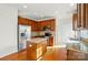 Well-equipped kitchen with stainless steel appliances, granite countertops, wooden cabinets, and hardwood floors at 3619 Grove Creek Pond Sw Dr, Concord, NC 28027