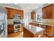 Well-lit kitchen featuring stainless steel appliances, granite countertops and wood cabinets at 3619 Grove Creek Pond Sw Dr, Concord, NC 28027