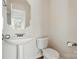 Cozy powder room features a pedestal sink and toilet, perfect for guests at 3619 Grove Creek Pond Sw Dr, Concord, NC 28027