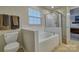 Bright bathroom featuring a separate shower and soaking tub with white tile surround and natural light from the window at 4011 Fenworth Ct, Fort Mill, SC 29715