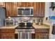 Kitchen featuring stainless steel microwave, oven, granite countertops, and wood cabinets at 4011 Fenworth Ct, Fort Mill, SC 29715