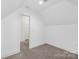 Attic room with finished carpet, bright lighting, and an entrance to another room, perfect for flex space at 4036 Meadowview Hills Dr # 7, Charlotte, NC 28269