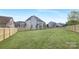 A large, fenced backyard of grass is framed by neighboring houses and blue skies at 4036 Meadowview Hills Dr # 7, Charlotte, NC 28269