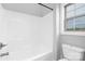 Bright bathroom featuring a white tub-shower combination and a window providing natural light at 4036 Meadowview Hills Dr # 7, Charlotte, NC 28269
