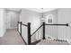 Hallway with carpet, classic black and white banister and modern light fixture enhancing the home's design at 4036 Meadowview Hills Dr # 7, Charlotte, NC 28269