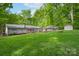 Expansive backyard view showcasing the home, wooden deck, and lush green lawn extending to a shed at 4256 Wood Forest Dr, Rock Hill, SC 29732
