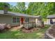Inviting backyard featuring a wooden deck, red door, and well-maintained lawn surrounded by mature trees at 4256 Wood Forest Dr, Rock Hill, SC 29732