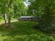 Lush greenery surrounds this quaint home featuring a detached garage and a well-maintained front lawn at 4256 Wood Forest Dr, Rock Hill, SC 29732