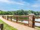 Scenic view of a tranquil community lake with a walking path and wooden fence along the shoreline at 4743 Morning Dew Ct # 4743, Charlotte, NC 28269