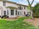 Back exterior showing large windows and patio door, complemented by a well-maintained lawn, creating an inviting outdoor space at 4743 Morning Dew Ct # 4743, Charlotte, NC 28269