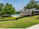 Community pool and clubhouse are beautifully landscaped with colorful flower beds, green lawns, and shaded areas at 4743 Morning Dew Ct # 4743, Charlotte, NC 28269