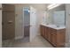 Bathroom with double sink vanity, walk-in shower, tile flooring, and doorway to bedroom at 5135 Norway Ln, Rock Hill, SC 29732