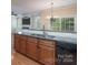 An open kitchen features wood cabinets, granite countertops, stainless steel sink, and a window view at 5135 Norway Ln, Rock Hill, SC 29732