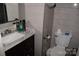 Compact bathroom featuring a dark vanity with white marble countertops and a tiled wall at 5915 Bluebonnet Rd, Charlotte, NC 28212
