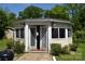 A well-lit outbuilding with a double door entrance and white trim is surrounded by greenery at 5915 Bluebonnet Rd, Charlotte, NC 28212