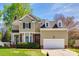 Charming two-story home with a manicured lawn, attached garage, and brick detailing under blue skies at 609 Tysons Forest Dr, Rock Hill, SC 29732