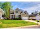 Charming two-story home boasts well-manicured lawn, brick accents, and attached garage under bright blue skies at 609 Tysons Forest Dr, Rock Hill, SC 29732