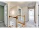 Hallway leading to carpeted bedrooms, featuring a stairway with wooden trim and a neutral color palette at 609 Tysons Forest Dr, Rock Hill, SC 29732