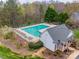 Aerial view of a community pool area, featuring lounge chairs and clubhouse, surrounded by lush trees at 609 Tysons Forest Dr, Rock Hill, SC 29732