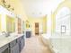 Bright bathroom featuring double doors, walk-in shower, soaking tub, and double sinks at 6123 Glen Manor Dr, Charlotte, NC 28269