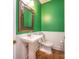 Powder room with pedestal sink, ornate mirror, white wainscoting and green painted walls at 6123 Glen Manor Dr, Charlotte, NC 28269