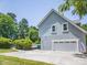 Side of home featuring a two-car garage, with a long driveway and landscaping at 6123 Glen Manor Dr, Charlotte, NC 28269
