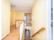 Hallway with hardwood floors, a white railing, and bright yellow walls at 6123 Glen Manor Dr, Charlotte, NC 28269