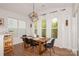 Bright dining room with wood table, black chairs, modern light fixture, and large windows with sheer white curtains at 620 Baneberry Bluff Ct, Rock Hill, SC 29732