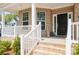 Inviting front porch featuring brick steps, white railings, and a stylish black front door at 620 Baneberry Bluff Ct, Rock Hill, SC 29732