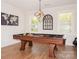 Well-lit game room with a stylish billiard table, hardwood floors, and modern light fixture at 620 Baneberry Bluff Ct, Rock Hill, SC 29732