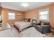 Cozy bedroom with two windows, neutral decor, and a comfortable seating area at 6310 Welford Rd, Charlotte, NC 28211