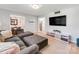 Living area with entertainment center and gray sectional sofa, offering easy access to dining room at 6310 Welford Rd, Charlotte, NC 28211