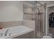 Well-appointed bathroom showcasing a tub and a tiled walk-in shower with a glass enclosure at 637 Amber Meadows Way, Fort Mill, SC 29708