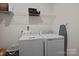 Functional laundry room with a washer, dryer, and storage shelves for laundry essentials at 637 Amber Meadows Way, Fort Mill, SC 29708