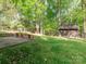Large backyard with grassy lawn, mature trees, and shed at 7024 Rockledge Dr, Charlotte, NC 28210