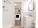 Bright bathroom with modern vanity, tiled shower, and view of laundry area with washing machine at 7024 Rockledge Dr, Charlotte, NC 28210