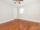 Bright bedroom with ceiling fan, hardwood floors, and a white door at 7024 Rockledge Dr, Charlotte, NC 28210